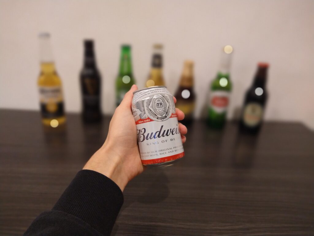 Stefan, the founder of Beveragebeaver.com, holding a can of Budweiser in his hand with other beers in the background