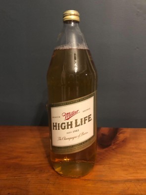 Miller high life transparent bottle on wooden surface