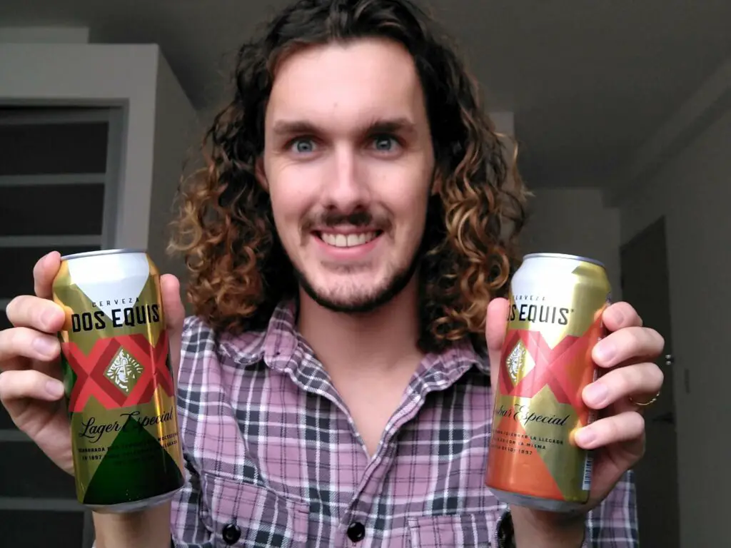 man holding cans of dos equis lager and dos equis ambar