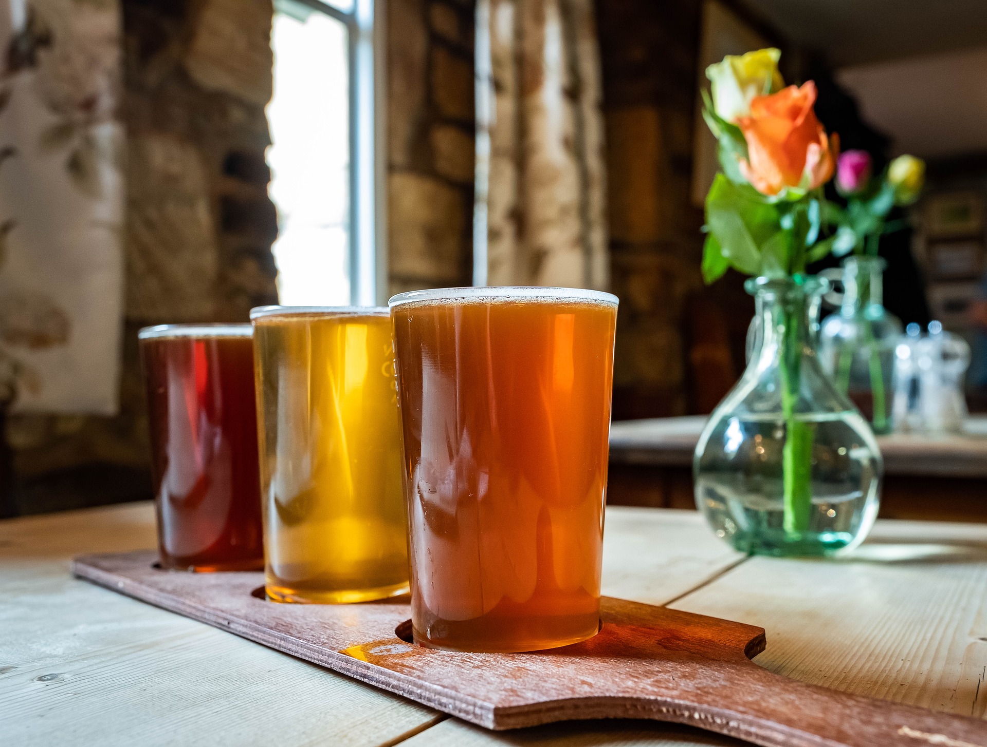 three different color beers in glass on table