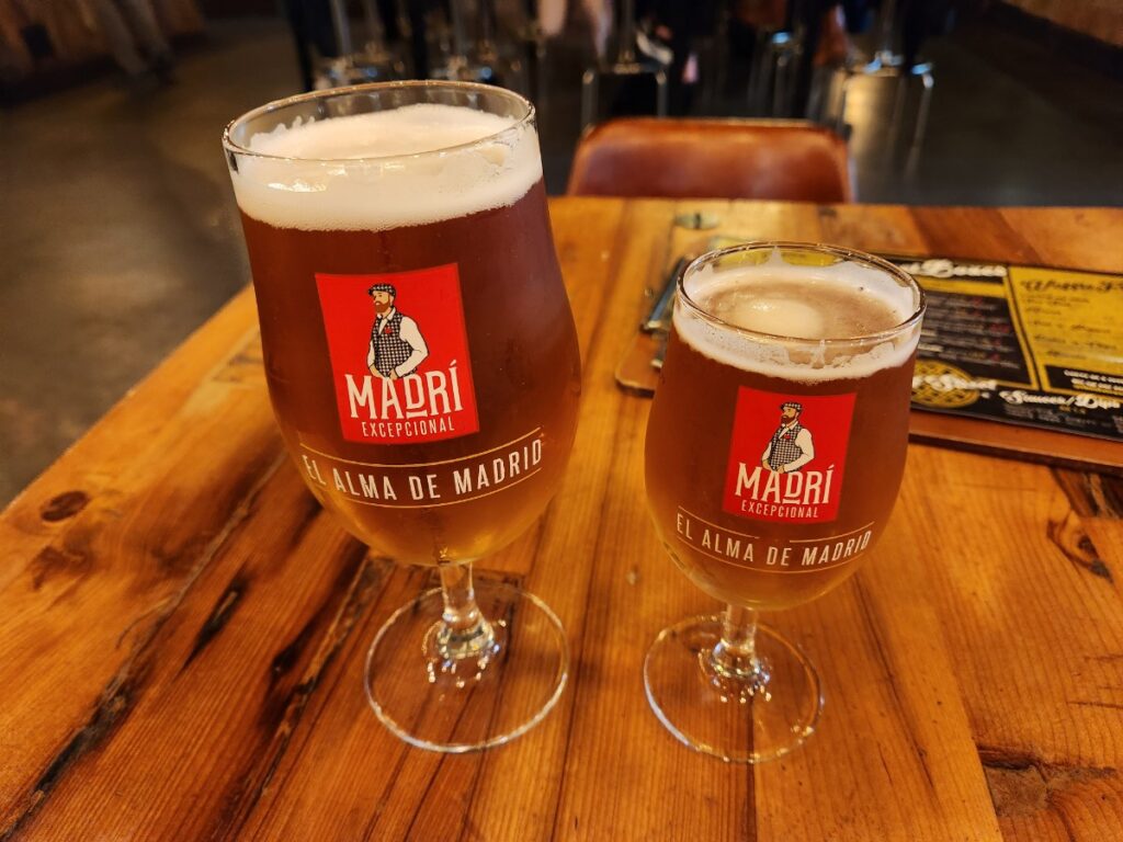 A picture of a Pint Of Madri Beer And A Half Pint Of Madri Beer