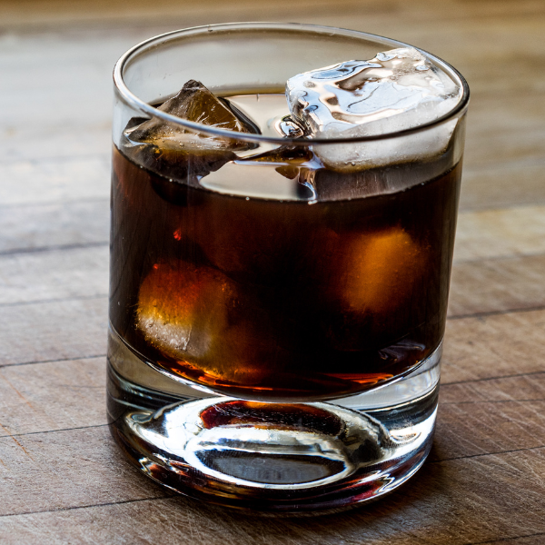A close up of a Black Russian Cocktail on table.