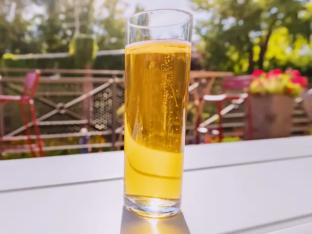 A Kolsch beer on a table in a beer garden.