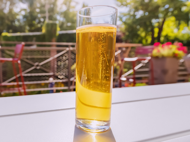 A Kolsch beer on a table in a beer garden.