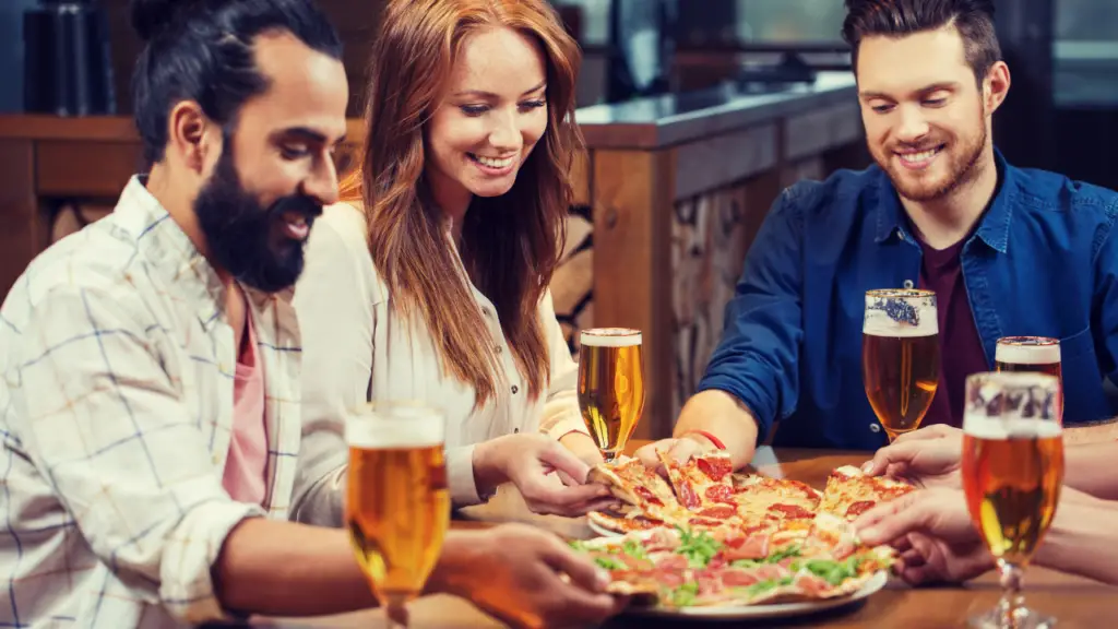 Three friends enjoying pizza and beer.